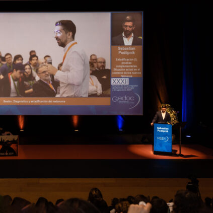 Sebastian Podlipnik presentando durante una conferencia de cáncer de piel en España