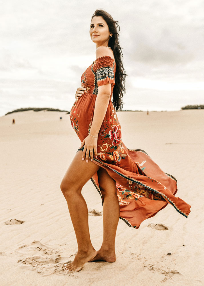 Mujer tomando el sol embarazada en la playa