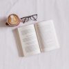 Skin care book on the bed with a cup of coffee